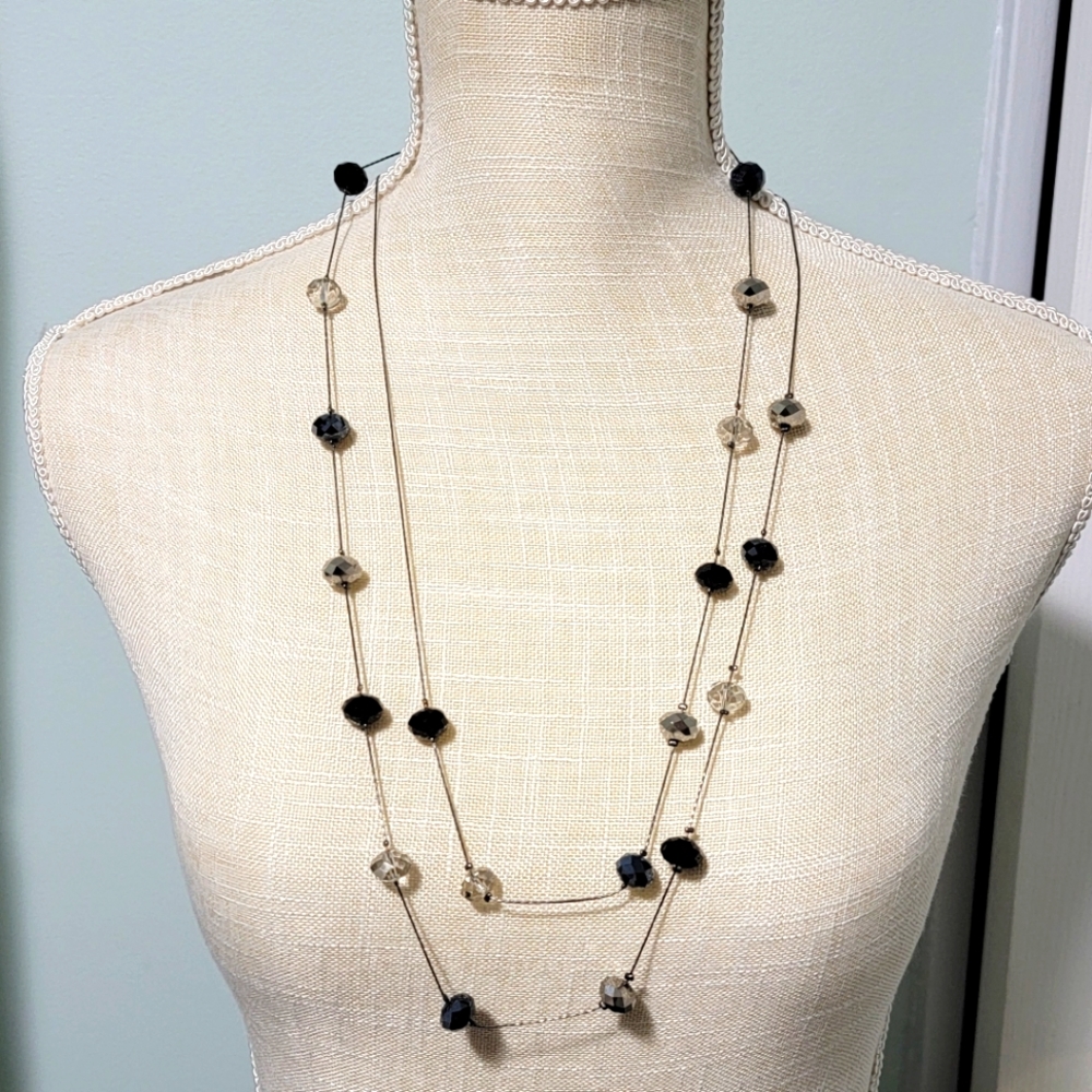 Long necklace with blue, black, and silver beads.